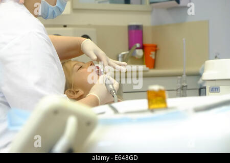 Junges Mädchen hat ihre Zähne gereinigt durch eine Dentalhygienikerin beim Zahnarzt Stockfoto