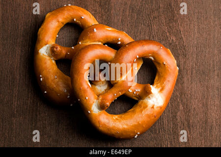 Zwei typische bayerische Brezel auf braunem Hintergrund Stockfoto