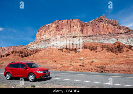 Ein rotes Auto parkte am Straßenrand in der Nähe des Capitol Reef National Park. Utah, USA. Stockfoto