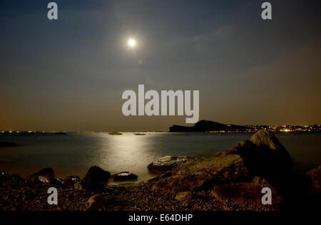 Mondlicht spiegelt sich auf dem ruhigen Dienst des Gardasees in der Nacht Stockfoto