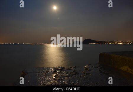 Mondlicht spiegelt sich auf dem ruhigen Dienst des Gardasees in der Nacht Stockfoto