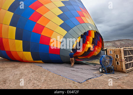 Mann bläst Heißluftballon für einen Flug. Moab, Utah, USA. Stockfoto