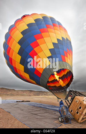 Heißluftballon wird für einen Flug mit einem Gasbrenner an Bord aufgepumpt. Moab, Utah, USA. Stockfoto