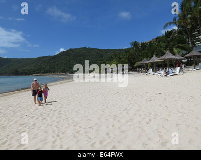 Junge Familie auf Hamilton Island in den Whitsunday Islands, Australien Katzenaugen Strand entlang spazieren. Stockfoto