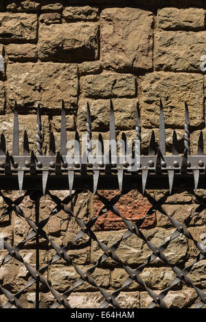 Feine schützende Barriere mit geschmiedeten Zinken und eine feste stoned Wand im Hintergrund in der Stadt von Leon, Spanien Stockfoto