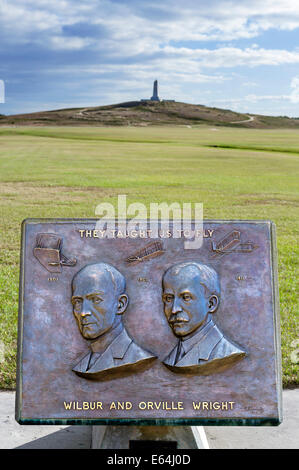 Plakette mit Wilbur und Orville Wright mit Denkmal hinter Wright Brothers National Memorial, North Carolina, USA Stockfoto