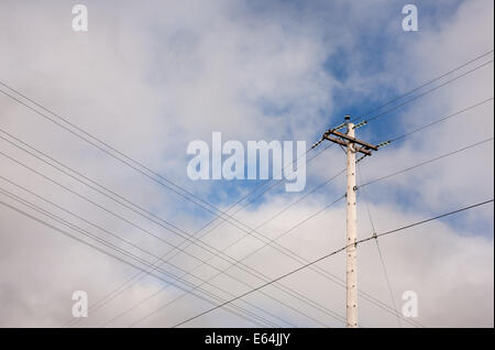 Hölzerne Telefonmast und teilweise bewölkter Himmel. Stockfoto