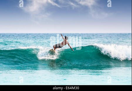 Silhouette eines Surfers auf Wellen am berühmten Strand in Sri Lanka. Stockfoto