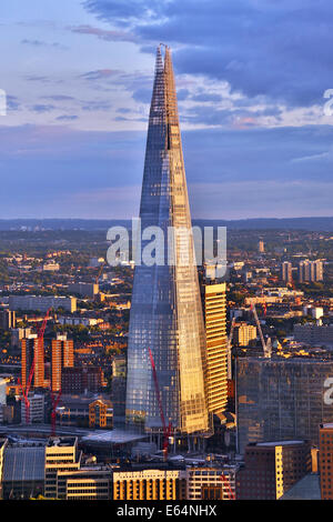 Gesamtansicht der Gebäude die Skyline der Stadt und die Scherbe in der Abenddämmerung in London, England Stockfoto