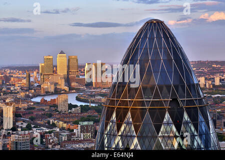 Gesamtansicht der Gebäude die Skyline von Canary Wharf und die Gurke, 30 St Mary Axe in der Abenddämmerung in London, England Stockfoto