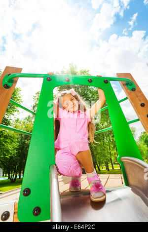 Mädchen stehen mit Knie beugen, auf der Rutsche Stockfoto