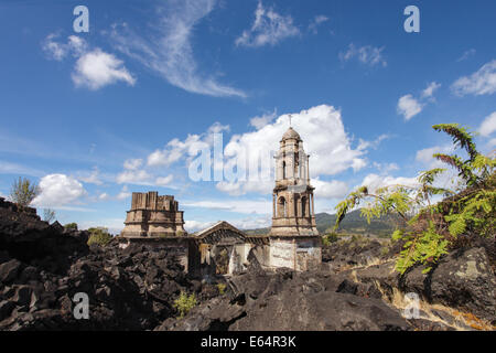 Die Türme des Tempels sind alle, die des Dorfes von Lava aus dem Vulkan Paricutín, Michoacan, Mexiko abgedeckt bleiben. Stockfoto