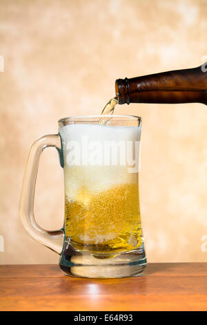 Eiskaltes, erfrischendes Bier in einem klassischen Bier Bierkrug zeigt die schmackhaften weißen Schaum und goldene Gebräu. Stockfoto