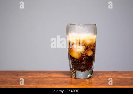 Frisch, knackig, kalte Cola in ein Trinkglas gegossen wird. Stockfoto