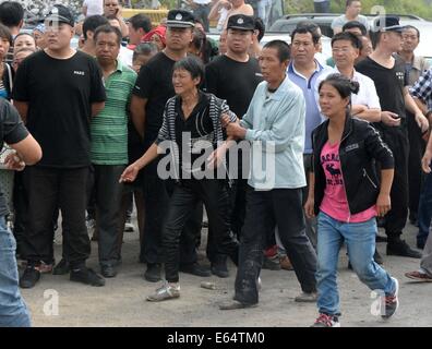Jixi, Chinas Provinz Heilongjiang. 15. August 2014. Angehörigen der eingeschlossenen Bergleute sind begierig zu sehen, gerettete Menschen außerhalb einer überfluteten Kohlengrube von Privatbesitz Anzhishun Coal Mine in Jixi, Nordost-China Provinz Heilongjiang, 15. August 2014. Neun Menschen wurden gerettet und 16 blieb in der überfluteten Kohlemine gefangen. Bildnachweis: Wang Kai/Xinhua/Alamy Live-Nachrichten Stockfoto