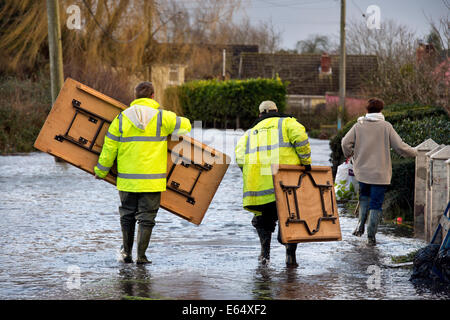 Bewohner tragen Posessions durch Hochwasser im Dorf Moorlandschaften auf der Somerset Levels UK Stockfoto