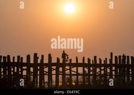 Mann mit dem Fahrrad auf einer Teak Brücke, U Bein Brücke über Thaungthaman See bei Sonnenuntergang, Amarapura, Mandalay-Division, Myanmar Stockfoto