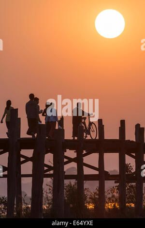 Einheimische und Touristen zu Fuß auf einer Teak Brücke, U Bein Brücke über Thaungthaman See bei Sonnenuntergang, Amarapura, Mandalay-Division Stockfoto