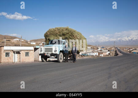 Kirgisische Männer stehen neben einem voll beladenen LKW, Sary-Tash, an der Grenze zu China, Osch, Kirgisistan Stockfoto