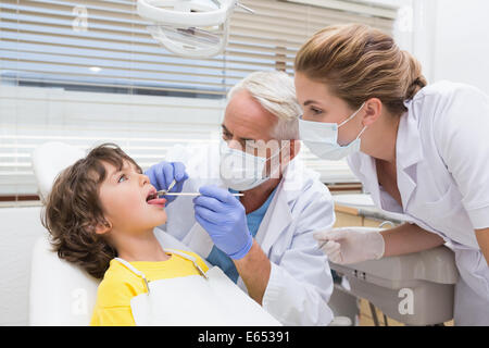 Kinderzahnarzt Prüfung eines kleinen Jungen Zähne mit seiner Assistentin Stockfoto