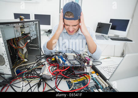 Verwirrt Informatiker arbeiten an defekten Konsole mit laptop Stockfoto