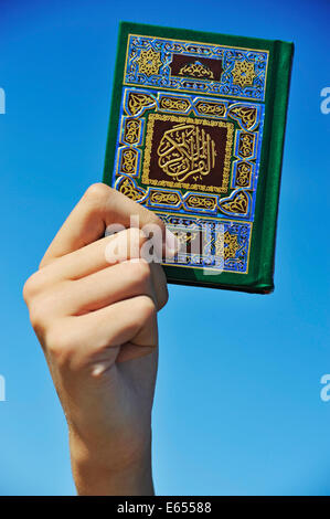 Hand, die das heilige Quran Koran-Buch Stockfoto