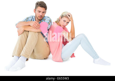 Attraktives junges Paar sitzt mit zwei Hälften an gebrochenen Herzen Stockfoto