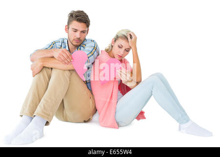 Attraktives junges Paar sitzt mit zwei Hälften an gebrochenen Herzen Stockfoto