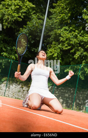 Hübsche Tennisspieler feiert einen Sieg Stockfoto