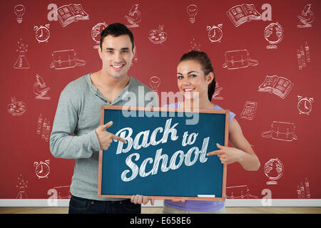 Zusammengesetztes Bild des Lächelns junges Paar auf Schild gerichtet halten Sie Stockfoto