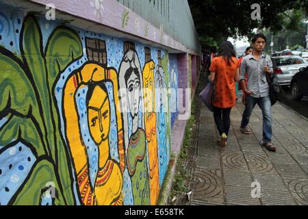 Bangladeshi student Pass durch ein Wandbild in der Universität von Dhaka. Stockfoto