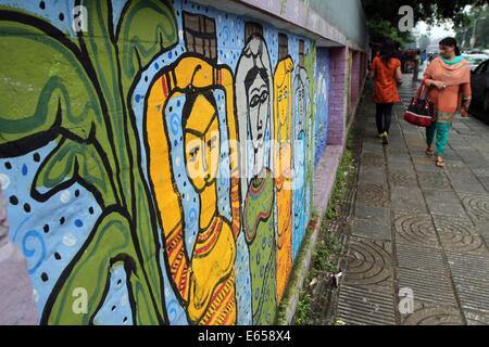 Bangladeshi student Pass durch ein Wandbild in der Universität von Dhaka. Stockfoto