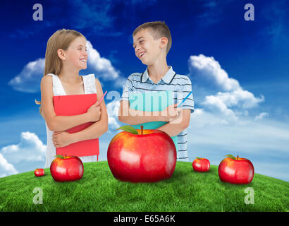 Zusammengesetztes Bild des Lächelns, Bruder und Schwester hält ihre Schulhefte Stockfoto