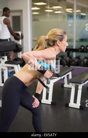 Seitenansicht des Fit Frau mit Hantel im Fitness-Studio trainieren Stockfoto