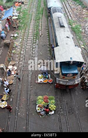 Leute kaufen und verkaufen Ware auf die Küche Markt auf der Schiene Linien in Karwan Bazar in Dhaka, 15. August 2014. der Eisenbahn, Bahn Linien Markt Stockfoto