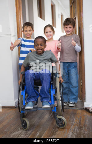 Behinderte Schüler mit seinen Freunden im Klassenzimmer Stockfoto