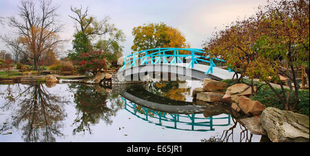 Eine pastorale Szene eine japanische Brücke über einem ruhigen kleinen Teich an einem regnerischen Tag im Herbst, südwestlichen Ohio, USA Stockfoto
