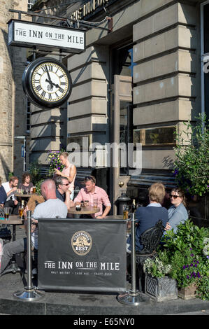 Menschen, die einen Drink außerhalb der Inn auf der Meile an einem Sommerabend auf der Royal Mile, Edinburgh Stockfoto