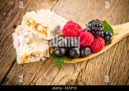 Müsliriegel mit frischen Beeren auf hölzernen Hintergrund Stockfoto