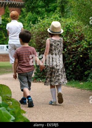 Jungen und Mädchen spazieren Hand in Hand, UK Stockfoto