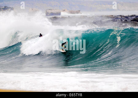 Eine lokale Surfer zieht in eine schwere, Ufer brechen Barrel im seichten Wasser an der Surf Break The Wedge in Newport Beach, Kalifornien Stockfoto