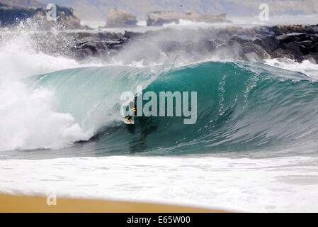 Eine lokale Surfer zieht in eine schwere, Ufer brechen Barrel im seichten Wasser an der Surf Break The Wedge in Newport Beach, Kalifornien Stockfoto