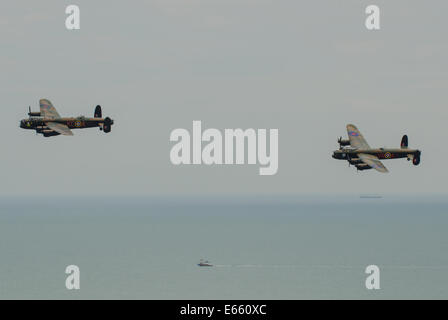 Zwei Avro Lancasters bei 'Airbourne' - das Eastbourne Airshow. Lancaster Bomber Flugzeuge fliegen in Formation über das Meer Stockfoto