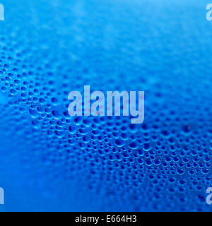 Wassertropfen auf blaue Flasche Hintergrund Stockfoto