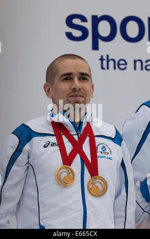 Glasgow, Schottland, Großbritannien. 15 Aug, 2014. Neil Fachie, MBE, Commonwealth Games Goldmedaillengewinner in der Schiene Radfahren im Para-Sport Tandem 1000 m Zeitfahren und die Tandem-Sprint auf dem George Square, am Ende der Parade zu grüßen Team Schottland nach Glasgow 2014 - eine Veranstaltung von Clyde - Siders, Host City Volunteers, und die Familien der Sportler. Stockfoto