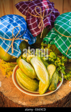 Saure Gurken auf einen Teller und Gläser mit Gurken Stockfoto