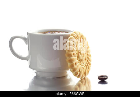 Tasse Kaffee und Gebäck mit Reflektion auf weißem Hintergrund. Selektiven Fokus. Stockfoto
