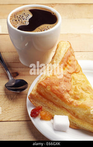 Kaffee und ein Croissant auf Holztisch Stockfoto