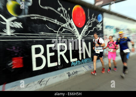 Berlin, Deutschland. 16. August 2014. Teilnehmer im Berliner 100 Meilen oder 100MeilenBerlin, entlang der Gedenkstätte Berliner Mauer an der East-Side-Gallery in Berlin, Deutschland, 16. August 2014 laufen. 2014 wird das 25-Jahr-Jubiläum der Fall der Berliner Mauer. Foto: WOLFGANG KUMM/Dpa/Alamy Live News Stockfoto