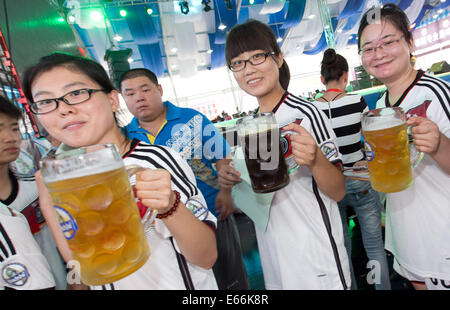 Qingdao, China. 16. August 2014. Kellner tragen Becher Bier während 24. Oktoberfest in Qingdao, China, 16. August 2014. Laut Veranstalter ist es zum größten Volksfest in Asien. Foto: FRISO GENTSCH/Dpa/Alamy Live News Stockfoto